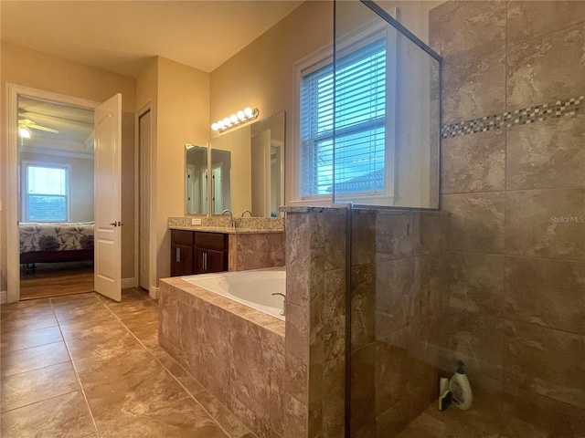 ensuite bathroom with tiled bath, ensuite bath, vanity, tile patterned floors, and walk in shower