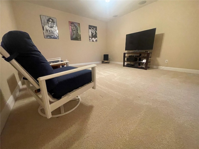 carpeted living area featuring baseboards