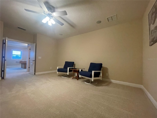 sitting room featuring light carpet, baseboards, and visible vents