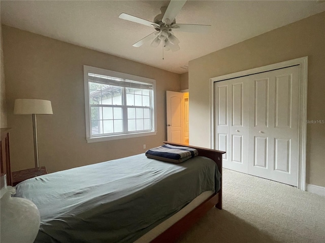 carpeted bedroom featuring a closet and ceiling fan