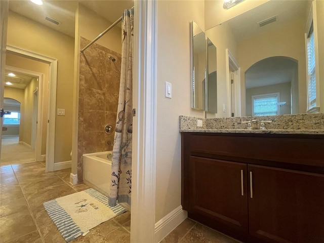 bathroom featuring visible vents, shower / bathtub combination with curtain, and baseboards