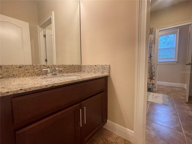 bathroom featuring a shower with shower curtain, vanity, and baseboards