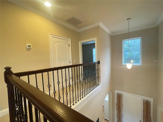 hallway featuring ornamental molding, baseboards, visible vents, and an upstairs landing