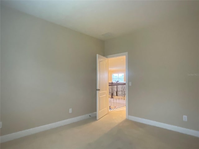 empty room with light carpet and baseboards