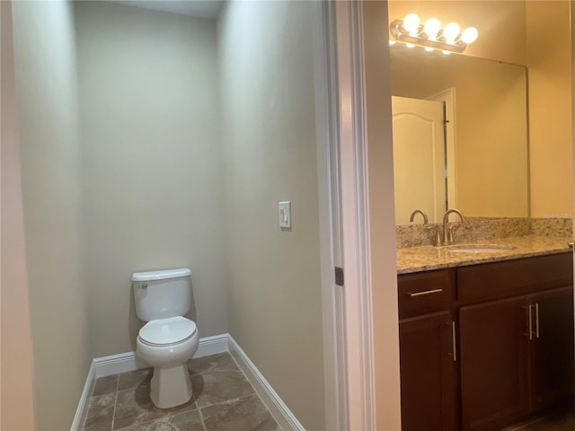 bathroom featuring vanity, toilet, and baseboards