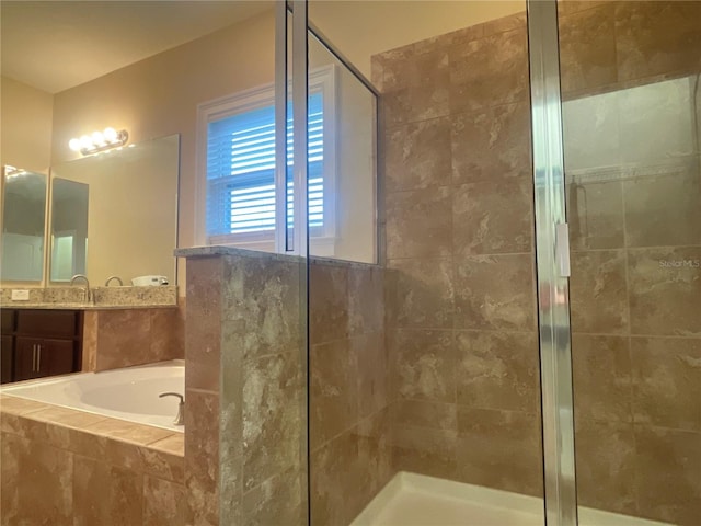 bathroom with a stall shower, a bath, and vanity