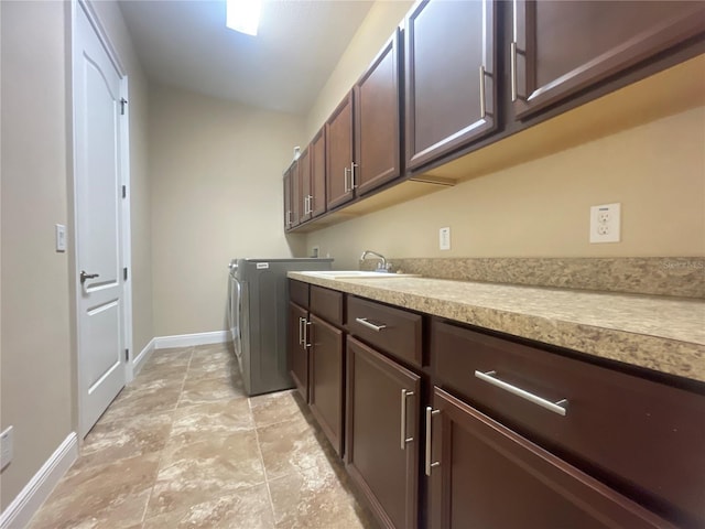 laundry area featuring a sink, cabinet space, and baseboards