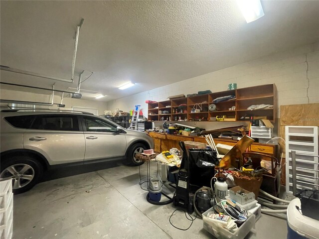 garage featuring a garage door opener and concrete block wall