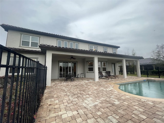 back of house featuring a patio area, fence, a ceiling fan, and stucco siding