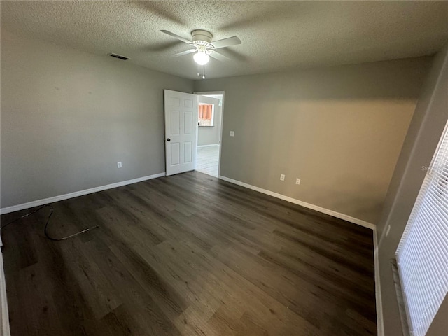 unfurnished bedroom with visible vents, baseboards, dark wood-style floors, ceiling fan, and a textured ceiling