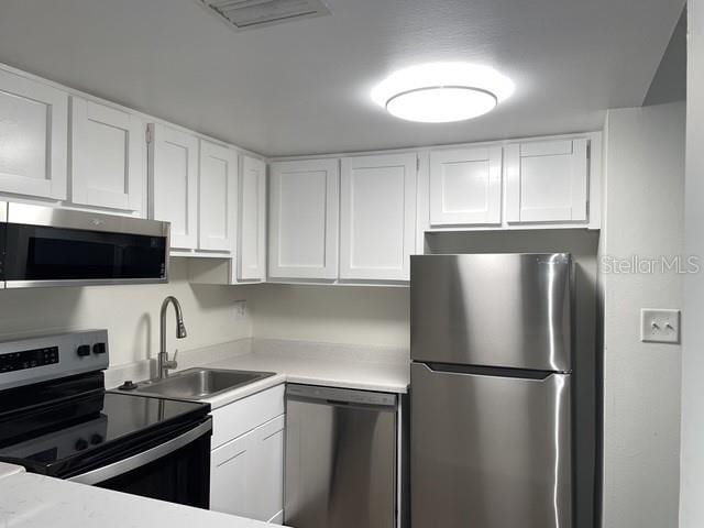 kitchen featuring white cabinetry, appliances with stainless steel finishes, and sink