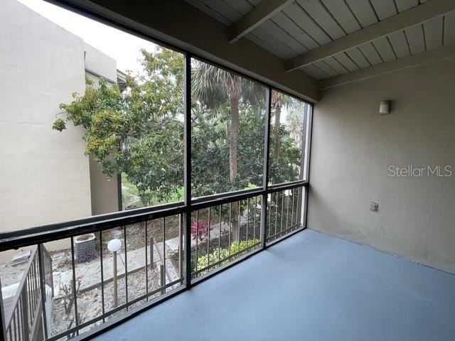 unfurnished sunroom featuring beamed ceiling