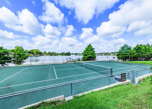 view of tennis court featuring a water view