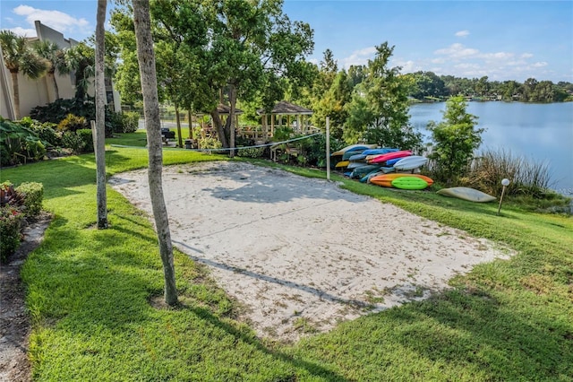 view of community featuring a yard, volleyball court, and a water view