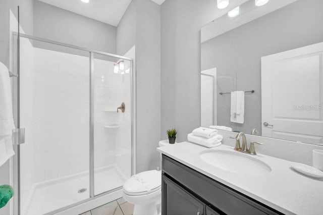 bathroom with toilet, a shower stall, and vanity