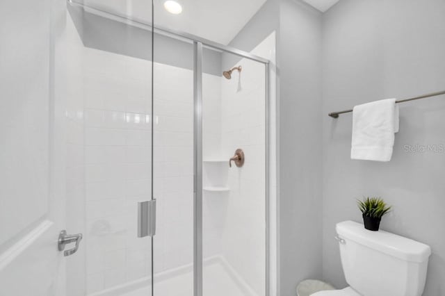 bathroom featuring a stall shower and toilet