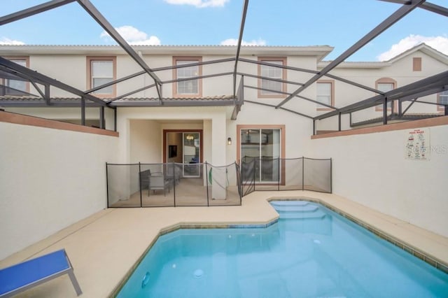 rear view of house with an outdoor pool, a patio, and stucco siding