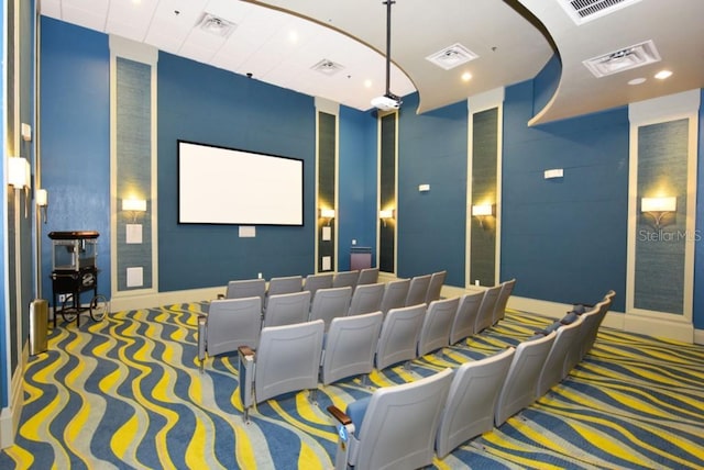 carpeted cinema with visible vents and baseboards