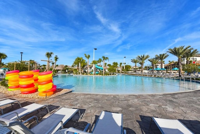 pool featuring a water slide and a patio area