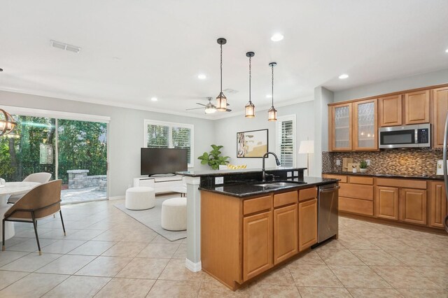 981 Galway Blvd, Apopka, FL 32703 - kitchen featuring stainless steel appliances, a center island with sink, a sink, backsplash, and light tile patterned floors