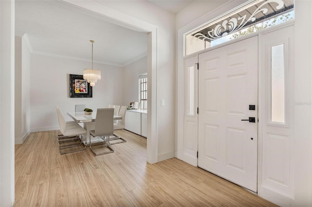 entryway featuring ornamental molding, light hardwood / wood-style flooring, and a wealth of natural light