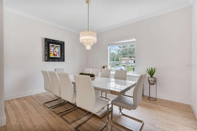 dining area with crown molding, an inviting chandelier, and light wood-type flooring