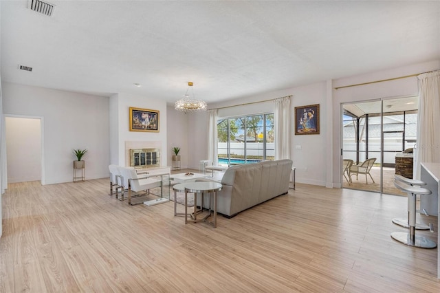 living room featuring a notable chandelier and light hardwood / wood-style flooring