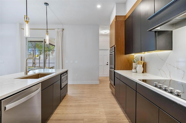 kitchen with sink, hanging light fixtures, light hardwood / wood-style flooring, stainless steel appliances, and backsplash