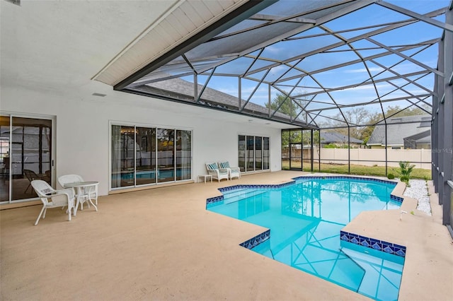 view of pool with a patio area and glass enclosure