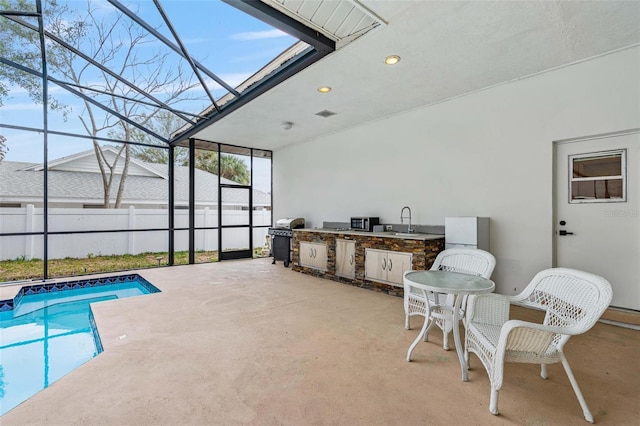 view of pool with area for grilling, a lanai, sink, and a patio area