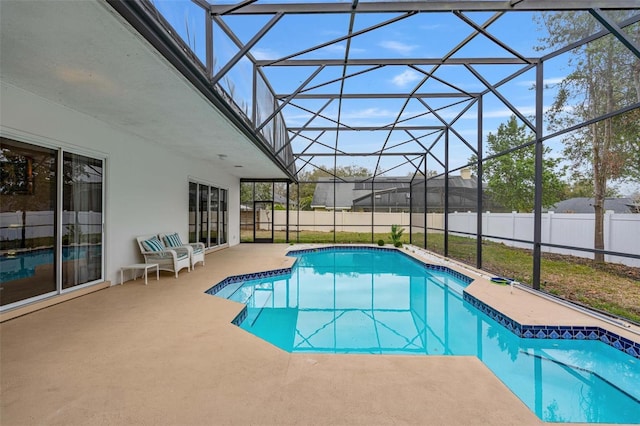 view of swimming pool featuring glass enclosure and a patio area