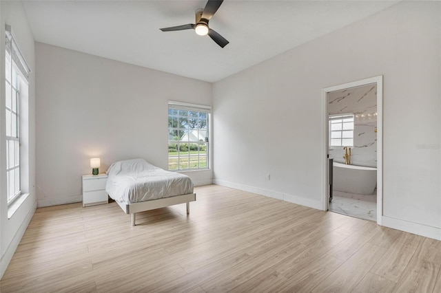 bedroom featuring ceiling fan, ensuite bathroom, and light hardwood / wood-style flooring