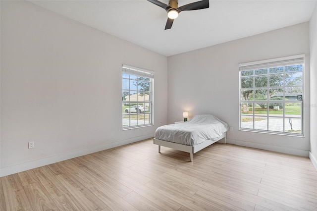 bedroom with ceiling fan and light wood-type flooring