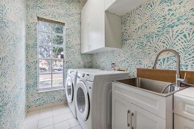 laundry room with light tile patterned flooring, cabinets, sink, and washer and dryer