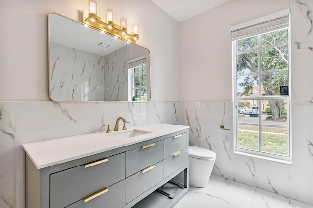 bathroom with vanity, tile walls, and toilet