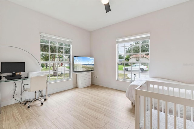 bedroom with multiple windows, ceiling fan, and light hardwood / wood-style floors