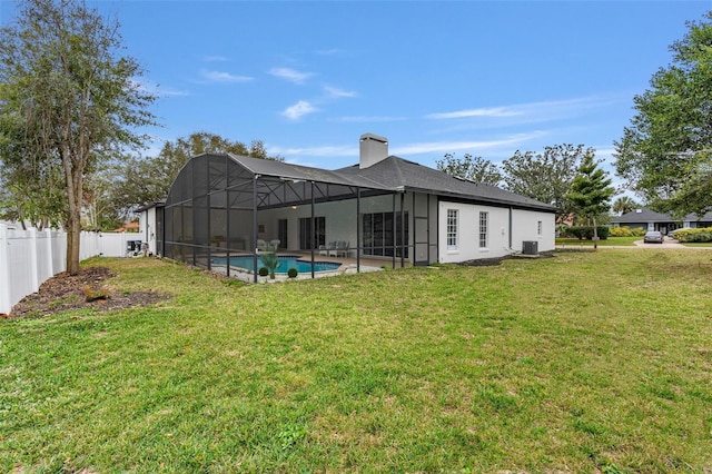 rear view of house featuring cooling unit, a yard, a lanai, and a fenced in pool