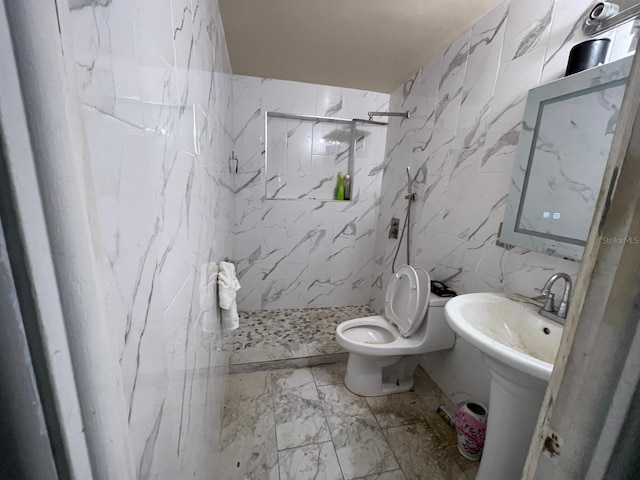 bathroom featuring a tile shower, tile walls, and toilet