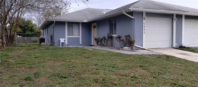 view of property exterior with a yard, fence, a garage, and stucco siding