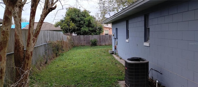 view of yard with a fenced backyard and central AC