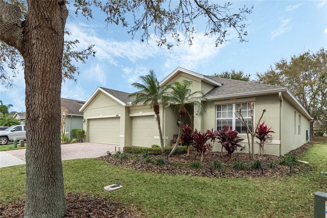 ranch-style house with a garage and a front lawn