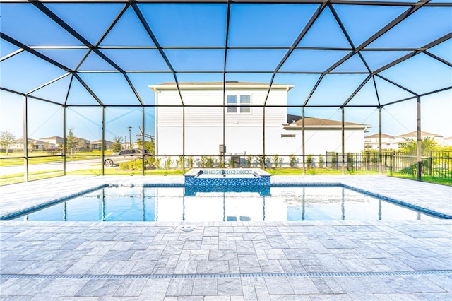 view of swimming pool with a patio area, an in ground hot tub, and glass enclosure