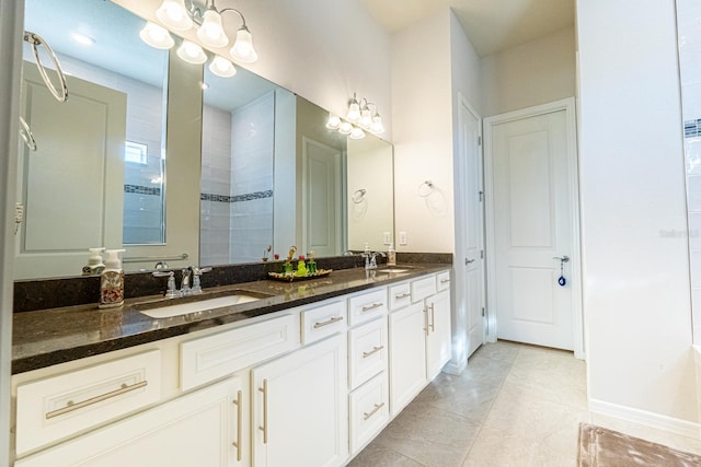 bathroom featuring double vanity, a stall shower, a sink, and an inviting chandelier