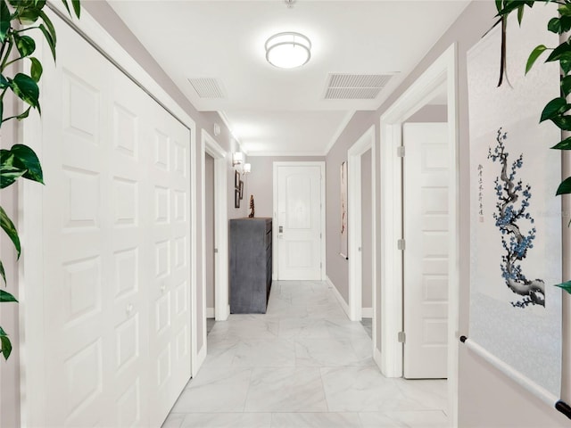 hallway featuring marble finish floor, baseboards, and visible vents