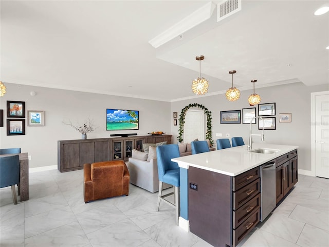 kitchen featuring a center island with sink, light countertops, ornamental molding, pendant lighting, and dishwasher