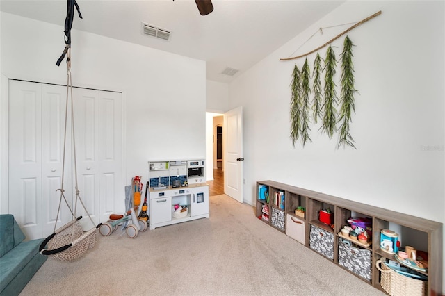 rec room with light carpet, ceiling fan, and visible vents