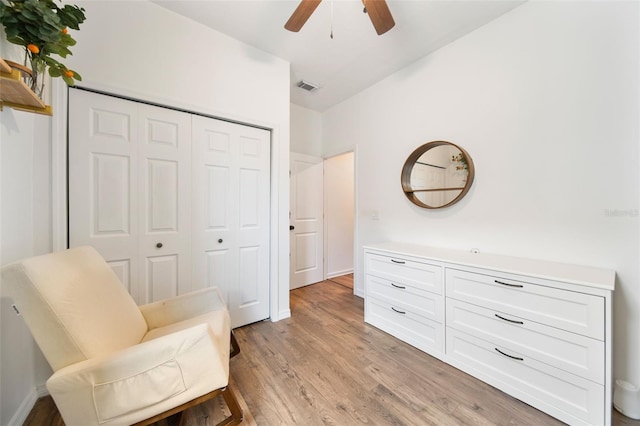 living area featuring light wood-type flooring, visible vents, ceiling fan, and baseboards