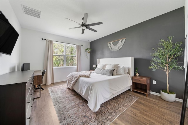 bedroom with visible vents, ceiling fan, baseboards, and wood finished floors