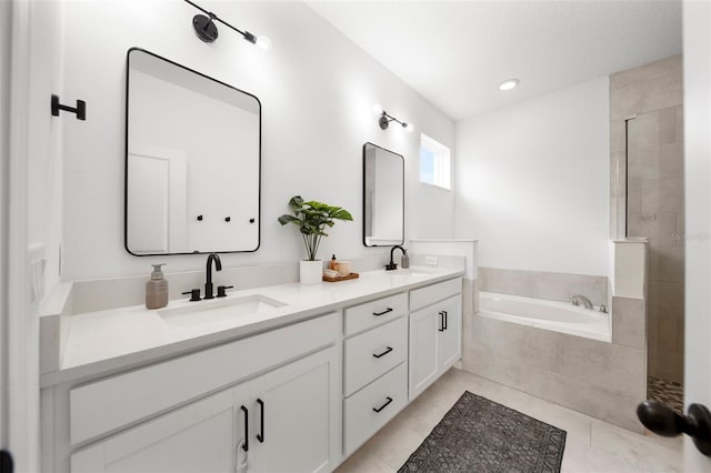 full bathroom with double vanity, a garden tub, a sink, and tile patterned floors