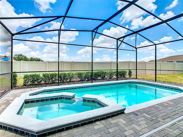 view of swimming pool with glass enclosure and an in ground hot tub